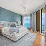 a beach-style guest bedroom with the cerulean teal and gray wall