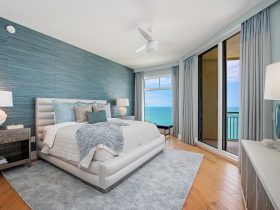 a beach-style guest bedroom with the cerulean teal and gray wall