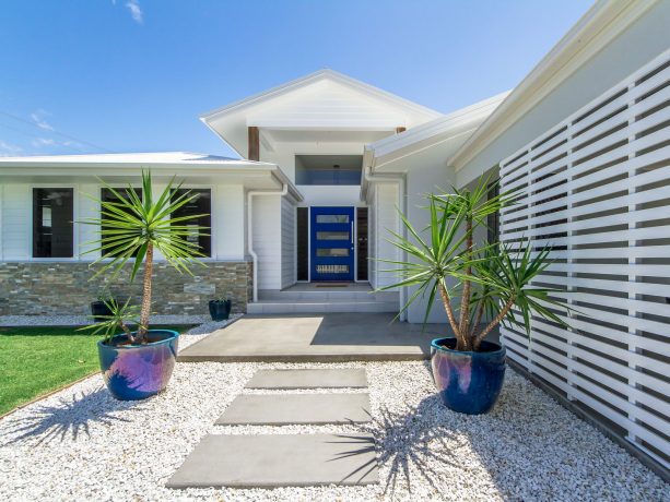 a coastal concrete floor entryway idea with a passionate blue dulux front door