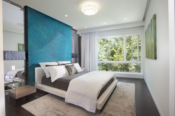 a contemporary bedroom with charcoal bed and teal headboard