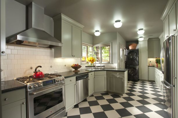 a handsome mix of checkered tile and sage green cabinets in a retro kitchen