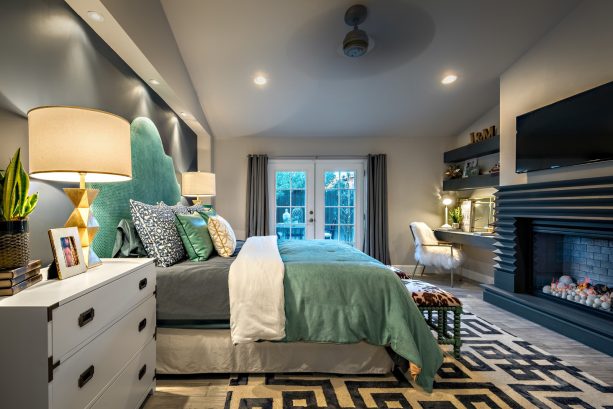 a mid-sized transitional master bedroom painted in the gray wall and ash-gray floor, teal and fog bed, and charcoal fireplace
