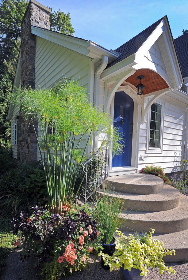 a small transitional wood exterior home with a benjamin moore down pour blue front door