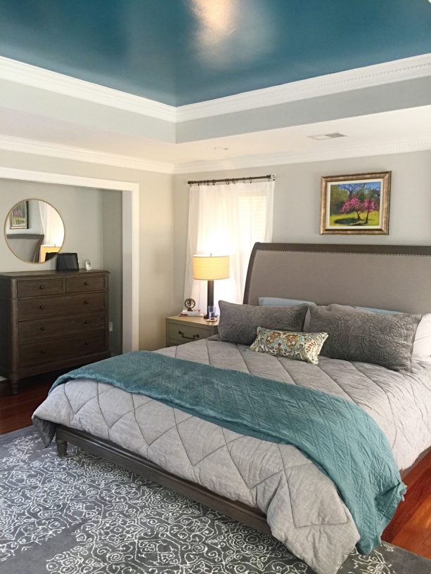 a transitional bedroom with a cloud gray wall and teal ceiling