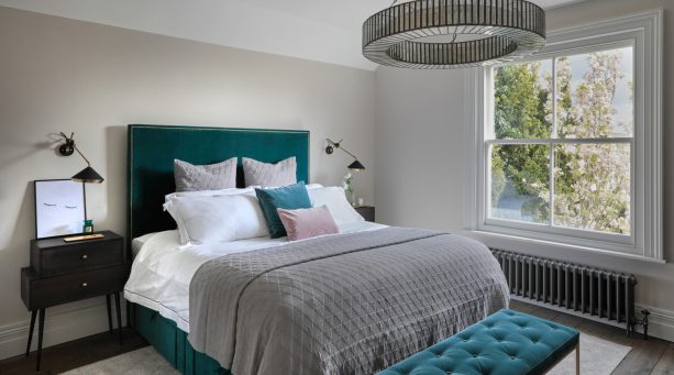 gray dominated mid-sized transitional bedroom with teal bed