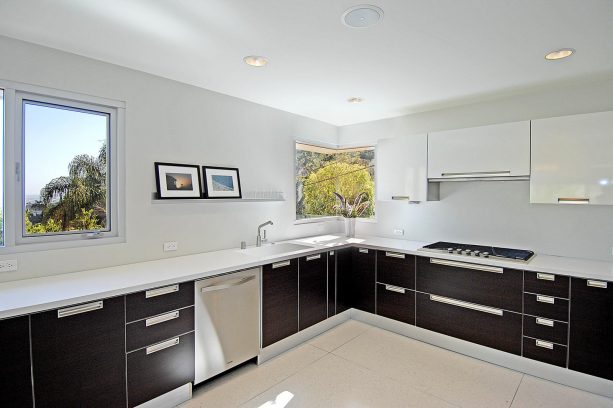 white flat-panel kitchen cabinets and black stainless steel appliances? why not?