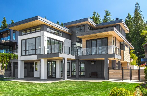 large trendy house featuring a metal roof and gray siding color combination