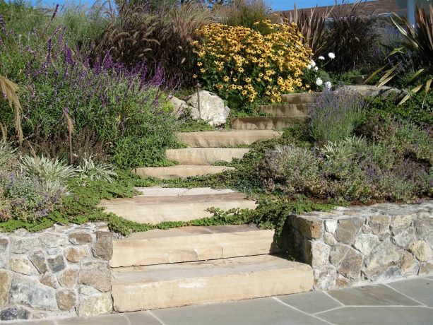 stone steps and perennial garden landscape on a hillside slope