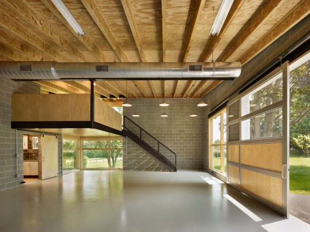 three-car stylish garage with a mezzanine apartment and a metal insulated glass door