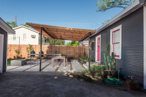 contemporary backyard with an attached pergola to a flat roof