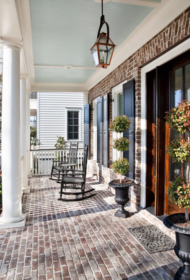 elegant porch of a brick house with charleston green shutters