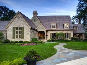 painted brick house exterior with mossy green shutters