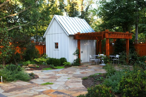 stained pergola attached to a roof of a cottage barn