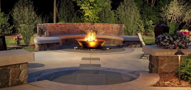 trendy granite fieldstone paver patio with semicircle bench around a fire bowl pit