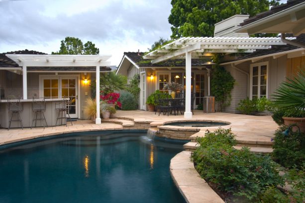 white structured pergola attached to a dark roof