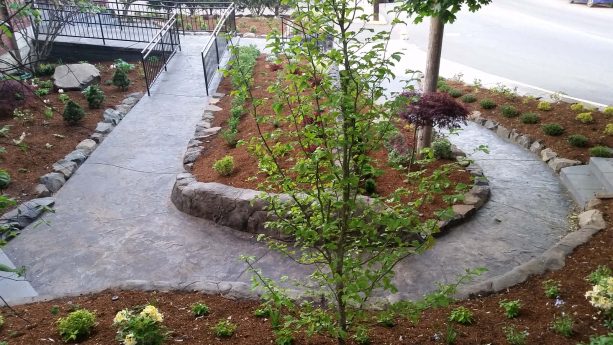 angular low stamped concrete retaining walls of a hillside landscaping