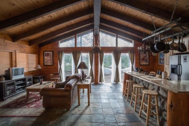 cabin living room and a kitchen combined together with stone slate tile floors