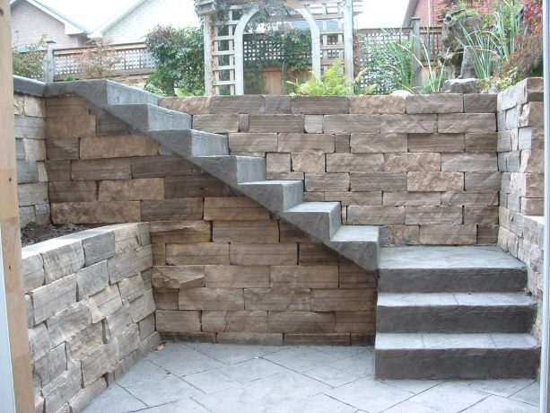 decorative stamped concrete retaining wall with attached outdoor staircase