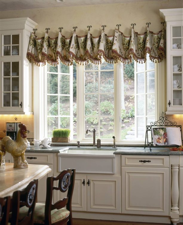 elegant kitchen with a sink and triple windows completed with unique valance treatment