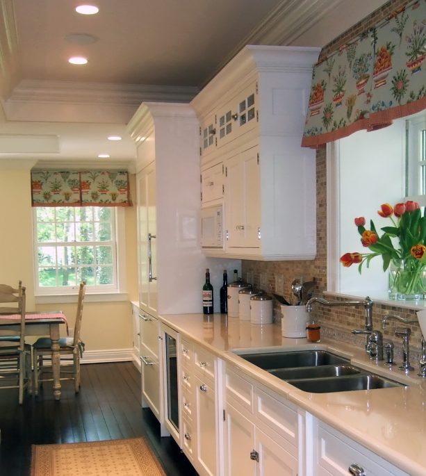 floral print valance window treatment over the triple-bowl kitchen sink