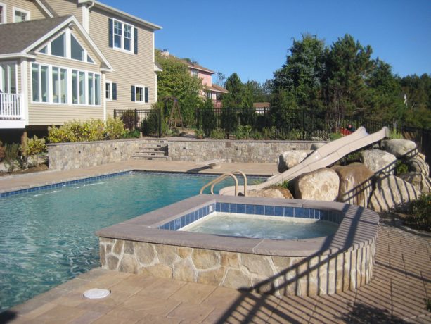 large modern backyard with stamped concrete retaining walls