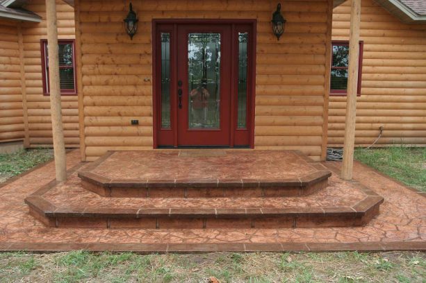 mid-sized stamped concrete paver steps against a log siding house