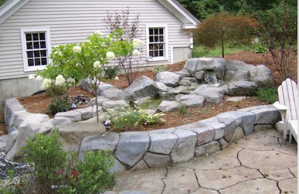 rock shaped stamped concrete retaining wall with rock fountain