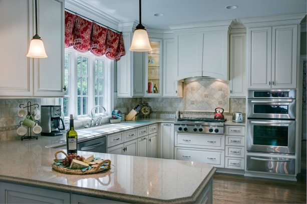 scalloped window treatment in red color over the kitchen sink
