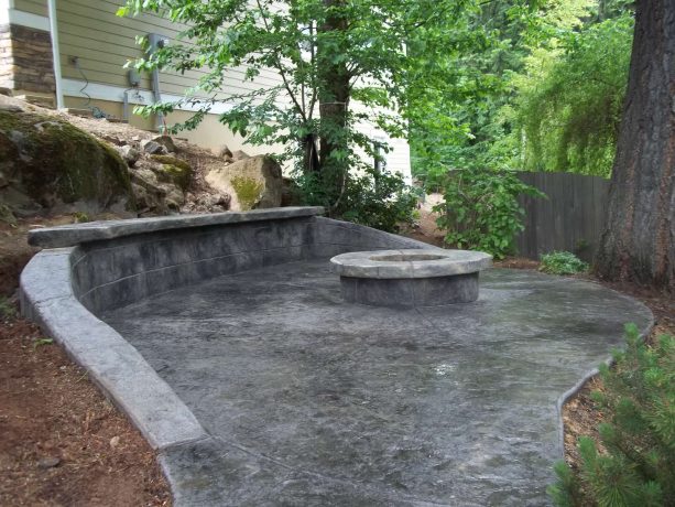 small contemporary backyard with stamped concrete retaining wall and bench cap