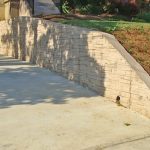 timeless textured stamped concrete retaining wall in a traditional landscape