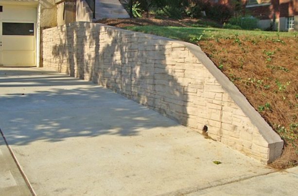 timeless textured stamped concrete retaining wall in a traditional landscape