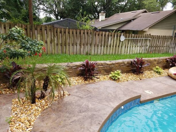 traditional style stamped concrete retaining wall beside the pool