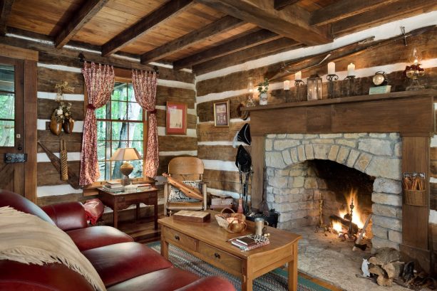 vintage log cabin living room with a stone fireplace