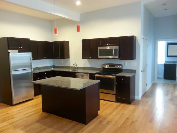 dark wood island with a granite top in a small yet elegant l-shaped kitchen