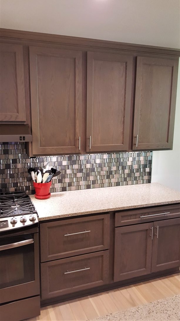 gray stained red oak cabinets with quartz countertops in a contemporary kitchen