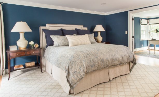 navy walls in a creamy white traditional bedroom