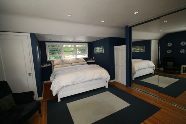 navy walls in a white arts and crafts bedroom with wood floor as an accent