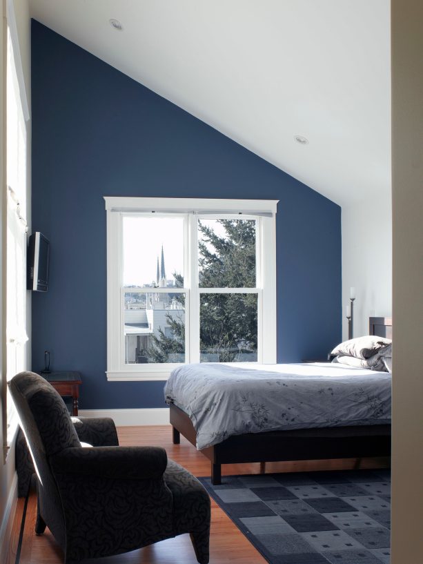 small white cathedral ceiling bedroom with navy wall