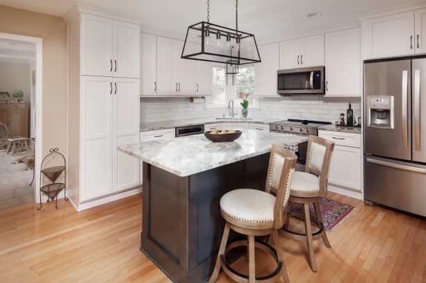 white and gray small kitchen in an l-shaped with a marble top island