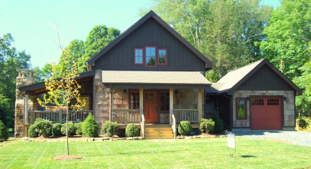 brown front door in a rustic exterior with black siding