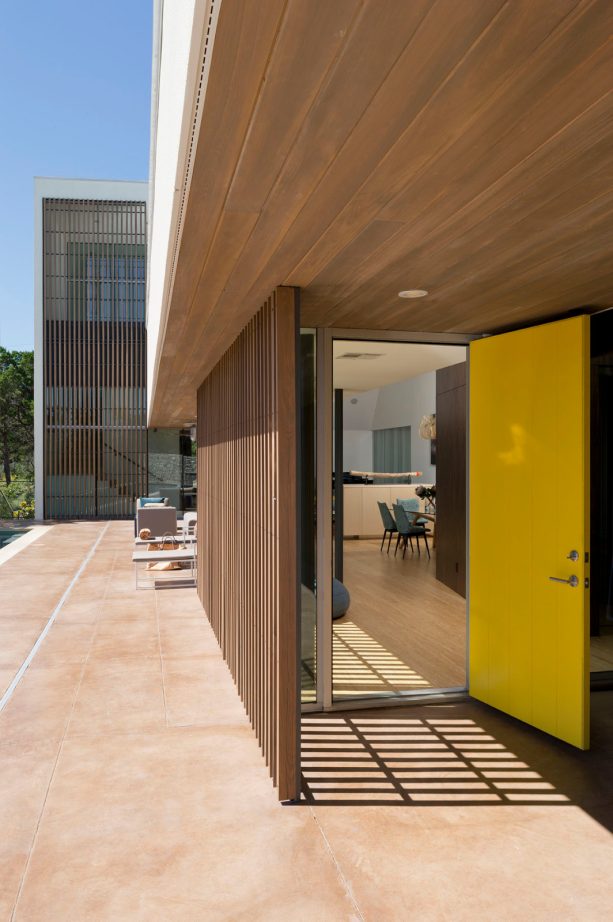 contemporary entryway with a yellow front door and a wood element