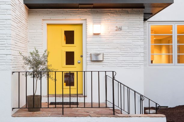 glass panel yellow front door in a mid-century entrance