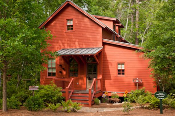 medium brown front door in a rustic red exterior