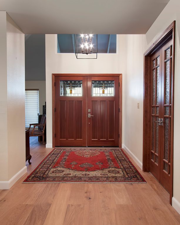 solid wood front door in brown color completed with top glass panels