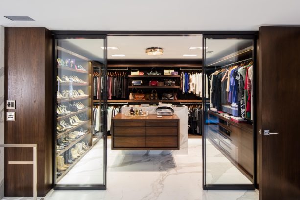 walk-in closet with a transparent sliding door and black frame