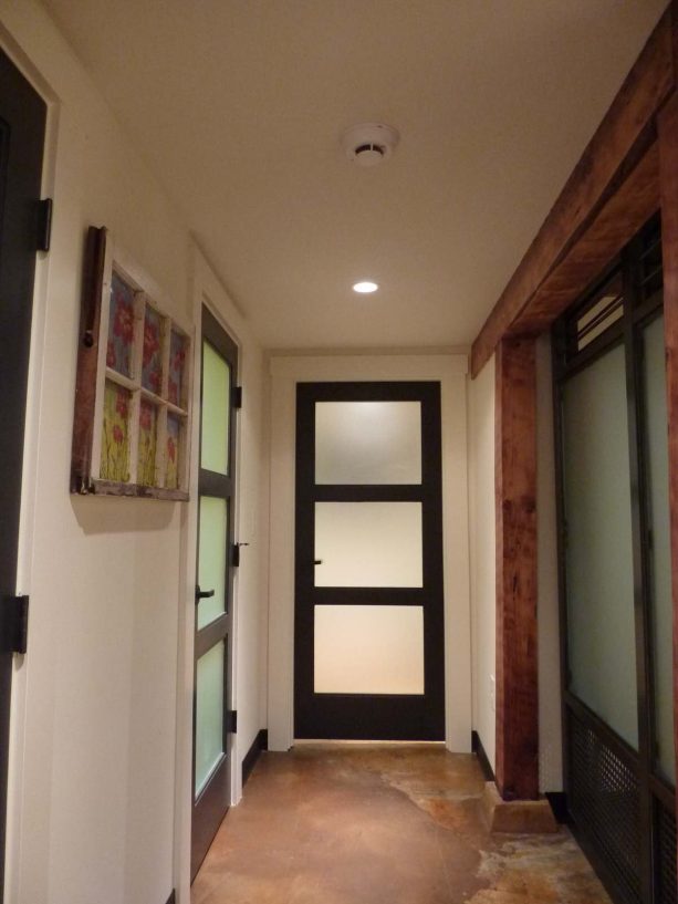 a glass panel door with dark trim for a minimalist hallway