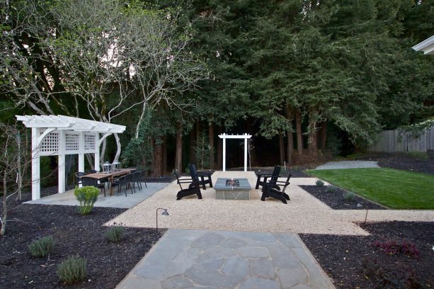 beige pea gravel fire pit surrounded by dark crushed stone and rock slab