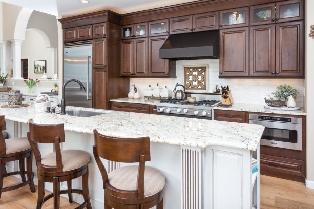 dark brown raised panel cabinets paired with white granite countertops