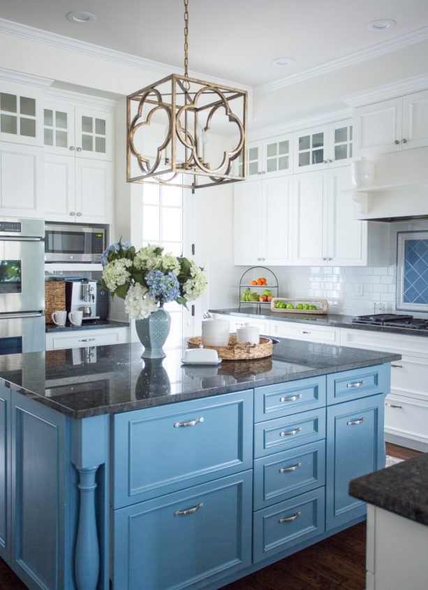 fresh blue island cabinets paired with dark granite top to bring out the modern look in the white cabinets around