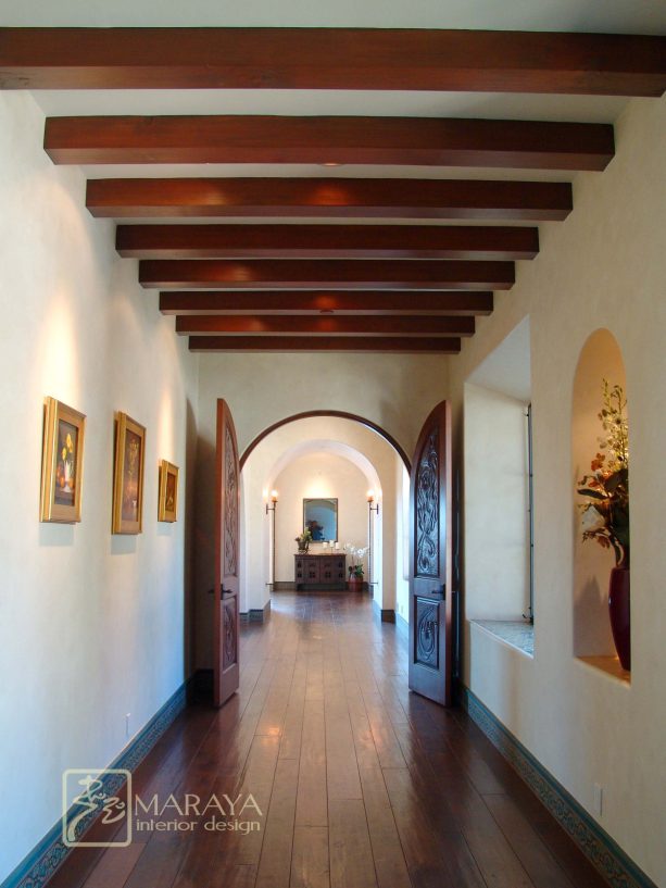 hand-carved hallway arched double doors in an old spanish luxe hallway